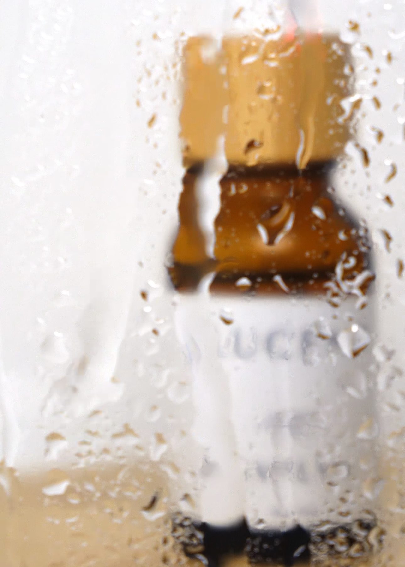 Close-up of a corked bottle with condensation on a white background